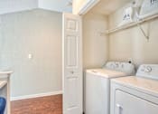 Thumbnail 8 of 21 - A laundry room with a washer and dryer.