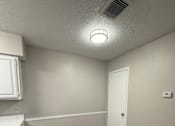 Thumbnail 4 of 10 - A room with a white door and a white cabinet with a counter top.