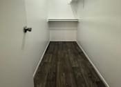 Thumbnail 10 of 10 - A long, narrow hallway with wood flooring and white walls.