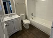 Thumbnail 9 of 10 - A bathroom with a toilet, sink, and bathtub.