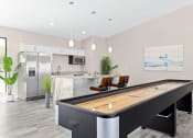 Thumbnail 11 of 16 - a games room with a foosball table and a kitchen in the background