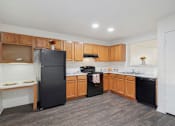 Thumbnail 1 of 16 - A kitchen with black appliances and wooden cabinets.