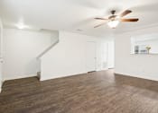 Thumbnail 4 of 16 - A room with a ceiling fan and wooden flooring.