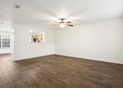 Thumbnail 5 of 16 - A room with a ceiling fan and wooden flooring.