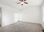 Thumbnail 8 of 16 - A room with a ceiling fan and carpeted floor.