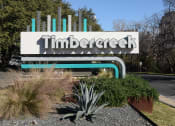 Thumbnail 16 of 17 - a sign for timbre creek in front of a road and trees