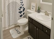 Thumbnail 7 of 23 - A bathroom with a toilet, sink, and shower curtain.