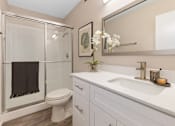 Thumbnail 6 of 23 - A bathroom with a toilet, sink, and mirror.