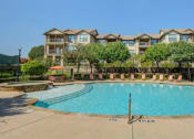 Thumbnail 22 of 35 - an outdoor pool with an apartment building in the background