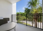 Thumbnail 6 of 66 - a balcony with a table and chairs and a palm tree