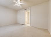 Thumbnail 6 of 23 - A white room with a ceiling fan and a door.
