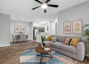 Thumbnail 41 of 45 - A living room with a grey couch, a coffee table, and a ceiling fan.