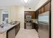 Thumbnail 38 of 44 - a modern kitchen with stainless steel appliances and granite counter tops