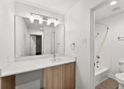Thumbnail 10 of 24 - a bathroom with a sink and a mirror and a shower