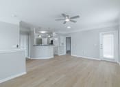 Thumbnail 27 of 39 - A spacious room with a ceiling fan and wooden flooring.
