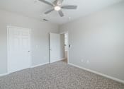 Thumbnail 31 of 39 - A room with a ceiling fan and two doors.