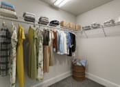Thumbnail 13 of 42 - a closet with clothes hanging on a rack and a basket on the floor