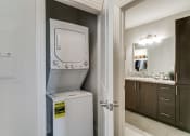 Thumbnail 18 of 42 - a white washer and dryer sitting on top of a refrigerator in a bathroom