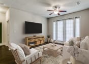 Thumbnail 9 of 42 - a living room with a ceiling fan and a tv