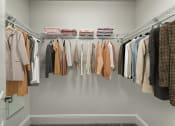 Thumbnail 16 of 42 - a closet with a rack of clothes hanging in it