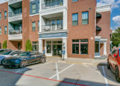 Thumbnail 33 of 42 - a building with a parking lot and cars parked in front of it