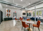 Thumbnail 27 of 42 - a lobby with tables and chairs and a living room with large windows