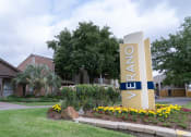 Thumbnail 36 of 37 - a building with a sign in front of a yard with flowers