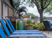 Thumbnail 32 of 37 - a patio with blue chairs and plants and a tree
