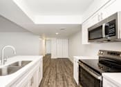 Thumbnail 25 of 42 - a kitchen with white cabinets and black appliances and a sink