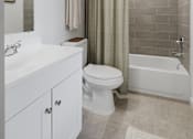 Thumbnail 34 of 41 - A white bathroom with a toilet, sink, and bathtub.