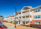 Thumbnail 28 of 29 - a row of apartment buildings with cars parked in front of them