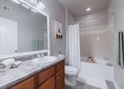 Thumbnail 16 of 42 - A bathroom with a white toilet, sink, and bathtub.