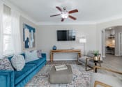 Thumbnail 1 of 42 - A living room with a blue couch, a television, and a rug.