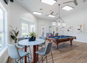 Thumbnail 21 of 42 - A room with a pool table and a dining table with chairs.