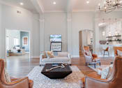Thumbnail 18 of 42 - A living room with a brown leather chair and a coffee table in the center.
