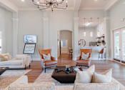 Thumbnail 17 of 42 - A living room with a chandelier, couches, and a coffee table.