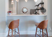 Thumbnail 26 of 42 - Two brown chairs are in front of a white desk with a mirror and some decorations.