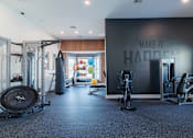 Thumbnail 29 of 42 - A gym with a variety of equipment including a treadmill, weights, and a punching bag.