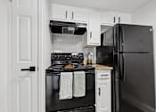 Thumbnail 21 of 38 - A black oven with a white towel hanging on it.