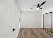 Thumbnail 29 of 38 - A room with a ceiling fan and wooden flooring.