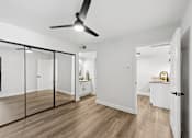 Thumbnail 26 of 38 - A room with a ceiling fan and a sliding glass door.