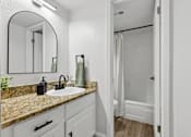 Thumbnail 30 of 38 - A bathroom with a sink, mirror, and shower.