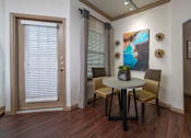 Thumbnail 5 of 28 - A dining room with a table and chairs.
