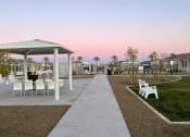 Thumbnail 16 of 18 - a pathway leading to a picnic area with chairs and tables