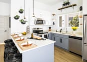 Thumbnail 1 of 18 - a kitchen with white walls and gray cabinets