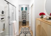 Thumbnail 7 of 18 - a small bathroom with a glass shower stall and a black and white rug