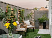 Thumbnail 9 of 18 - a patio with chairs and a table with a vase of flowers on it