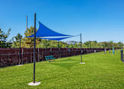 Thumbnail 21 of 24 - a park with a blue canopy and a bench