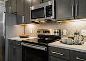 Thumbnail 4 of 33 - a kitchen with gray cabinets and white countertops