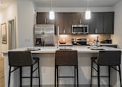 Thumbnail 15 of 33 - a kitchen with a large island with three stools